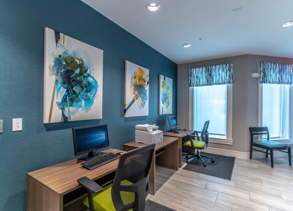 business center with two computers, chairs, and a printer
