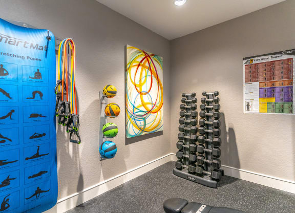 a home gym with weights and a large colorful graphic on the wall