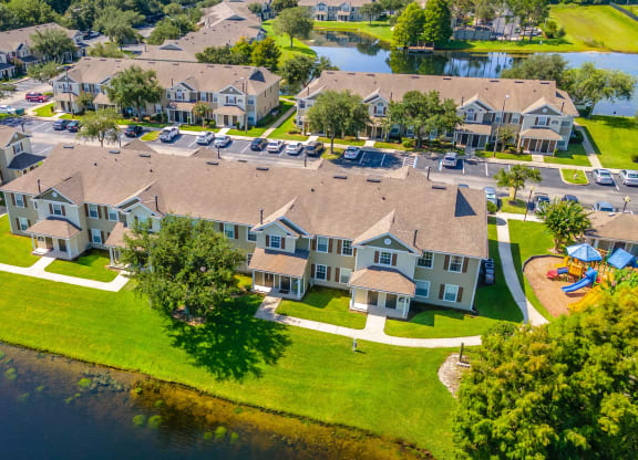 a large house sits on a grassy area next to a body of water