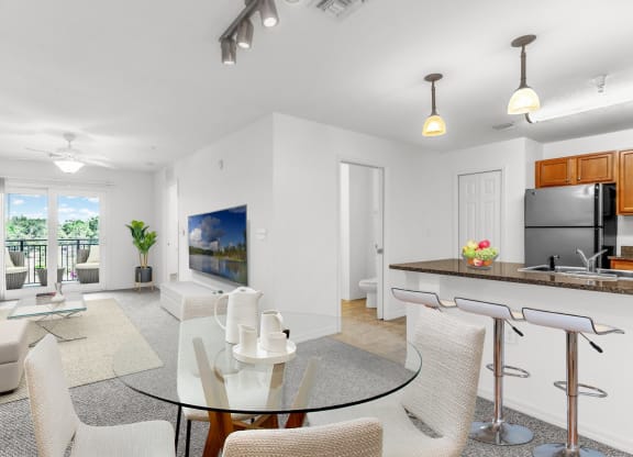 a living room with white walls and a glass table with white chairs