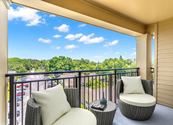 a balcony with two chairs and a table