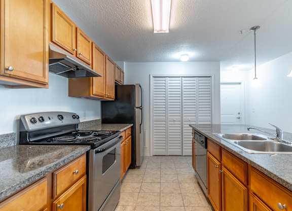 A kitchen with wooden cabinets and a black stove top oven.