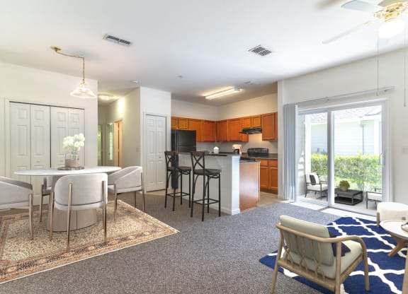 a living room and kitchen with a sliding glass door