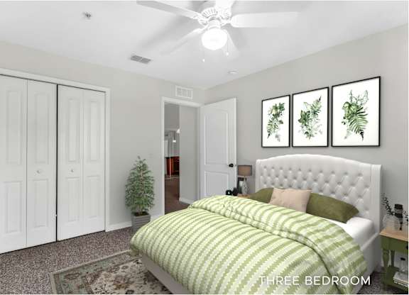 A bedroom with a bed, a ceiling fan, and a wall hanging with three framed plants.