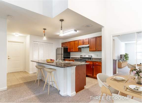 A kitchen with a bar stool and a dining table.