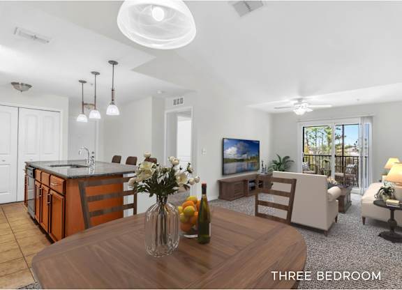 A well-lit, spacious kitchen and living room with a dining area and a flat-screen TV.