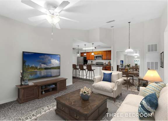 A living room with a television and a three bedroom sign.