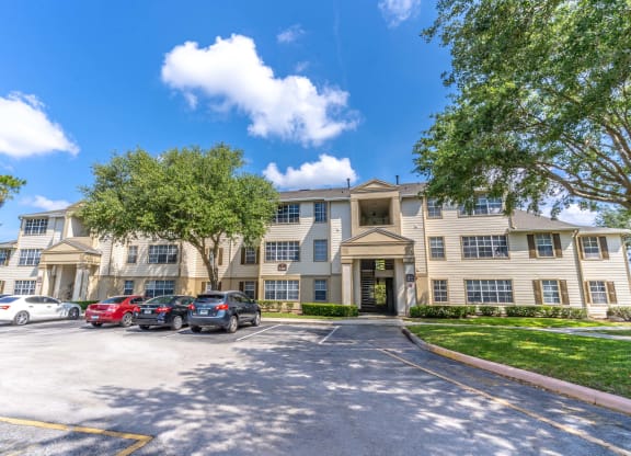 a large apartment building with a parking lot in front of it