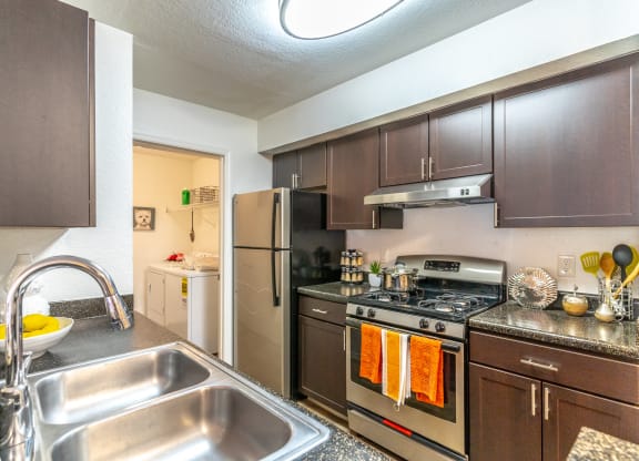 a kitchen with brown cabinets and stainless steel appliances
