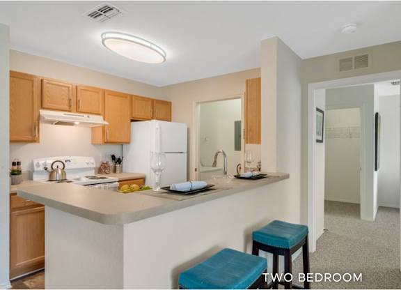 A kitchen with a bar stool in front of it.