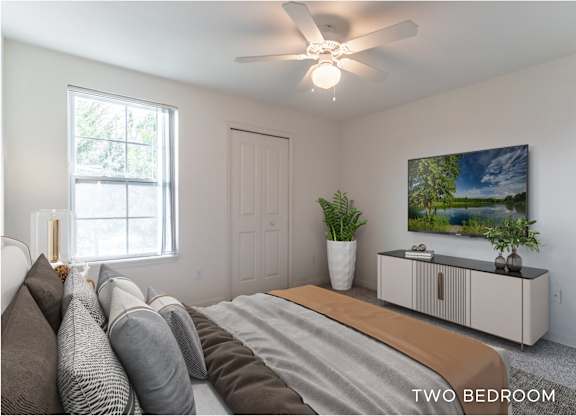 A bedroom with a bed, pillows, a ceiling fan, and a painting on the wall.