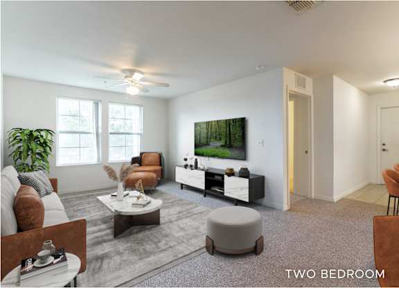 A living room with a couch, chairs, and a television.