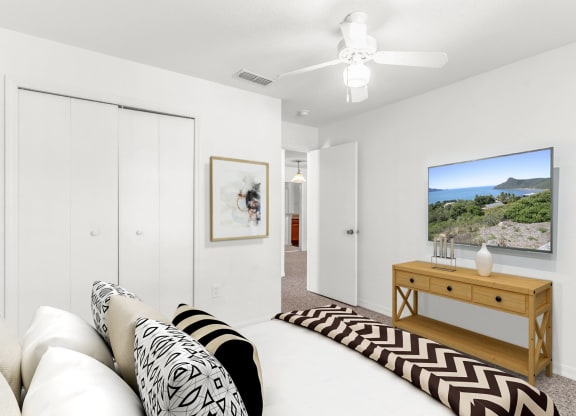 a bedroom with a large bed and a ceiling fan