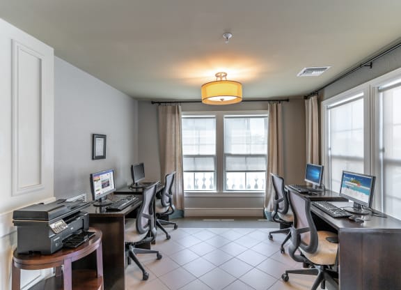 a computer room with several computers on the desks and a printer on a table