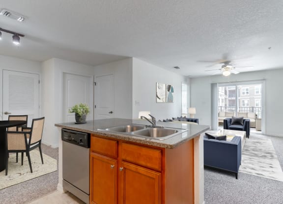 a kitchen with an island and a living room in the background