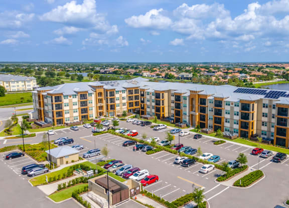 an aerial view of a large apartment complex with a parking lot and a lake in the background