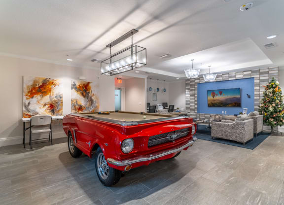 a red pool table in a room with a christmas tree
