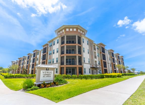 a large apartment building with a sidewalk in front of it