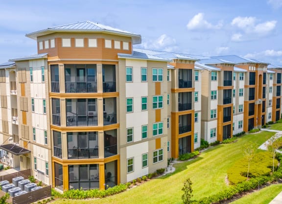 a large apartment complex with a grassy area in front of it
