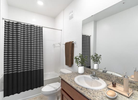 a bathroom with white walls and a black and white shower curtain