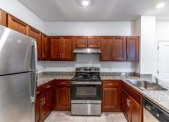 a kitchen with wooden cabinets and granite countertops