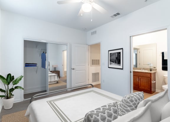 a bedroom with a large bed and a bathroom in the background