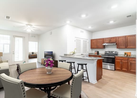 a kitchen and living room with white walls and wood flooring
