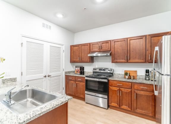 a kitchen with wooden cabinets and a stainless steel sink