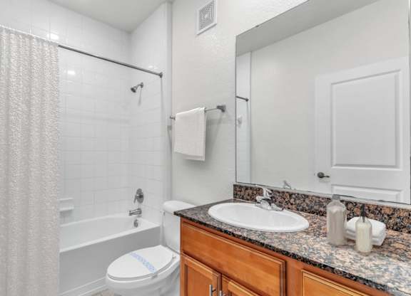 A white bathroom with a toilet, sink, and shower.