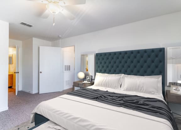 a bedroom with a large bed and a ceiling fan