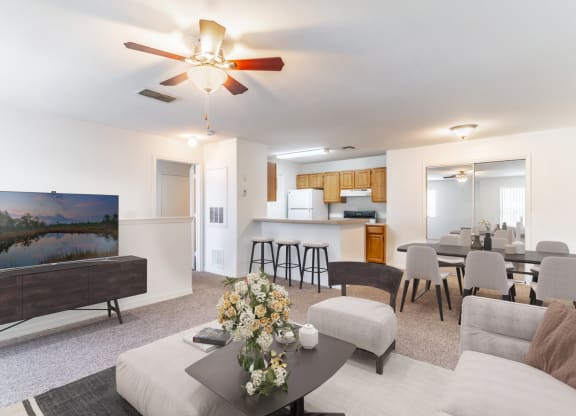 a living room with a ceiling fan and a flat screen tv