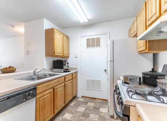 a kitchen with wooden cabinets and white appliances