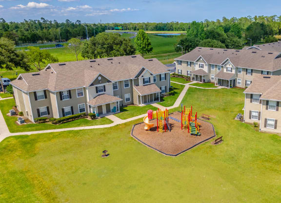 an aerial view of a playground in front of a row of houses