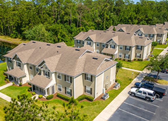 an aerial view of a row of apartment homes with a lake in the background