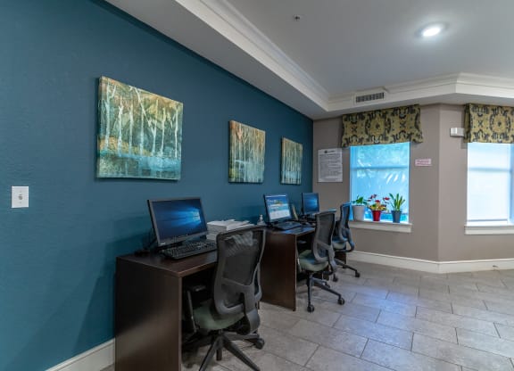 the business center with three computers and three chairs