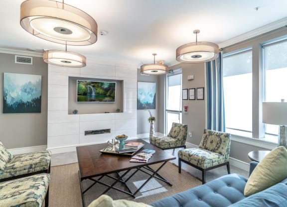 a clubhouse room with couches chairs tv and a coffee table