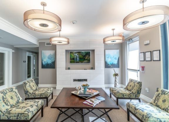 a clubhouse room with couches chairs tv and a coffee table
