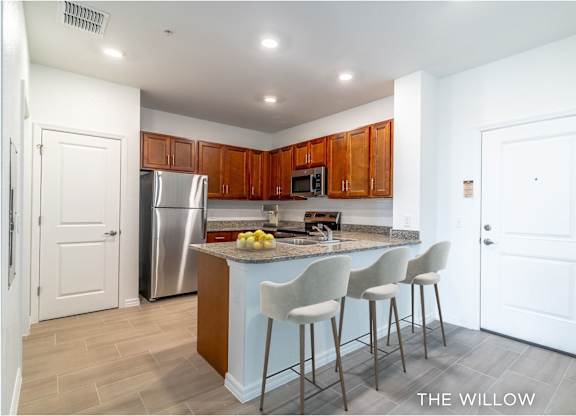 A kitchen with a bar and stools.