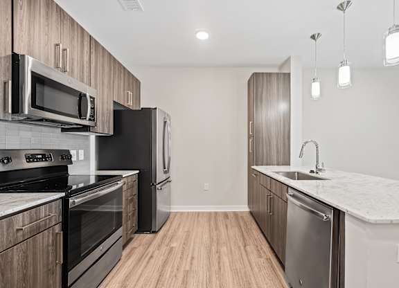 A modern kitchen with stainless steel appliances and wooden cabinets.