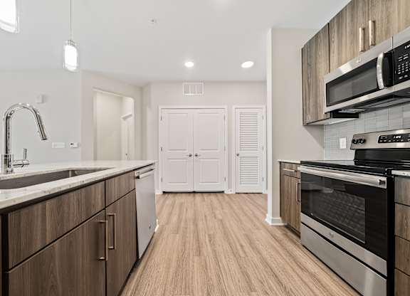 A modern kitchen with wooden cabinets and stainless steel appliances.
