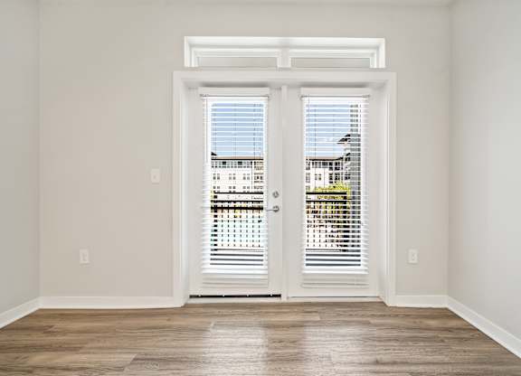 A room with a view of a building through the window.