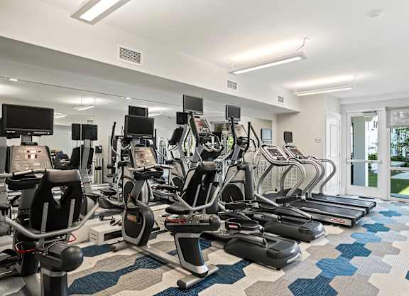 A gym with treadmills, exercise bikes and other equipment.