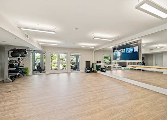 A spacious room with a large screen and a wooden floor.
