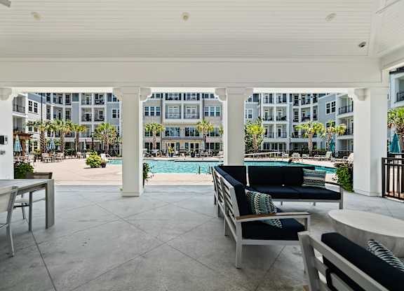 A patio with a pool and chairs.