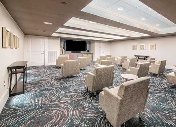 A conference room with a carpeted floor and a projector screen.