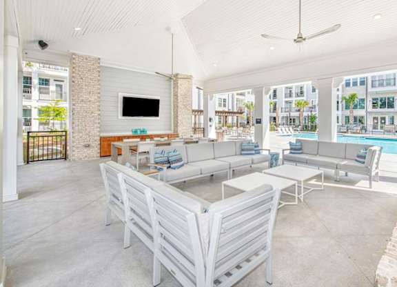 A large white room with a pool table and a television.