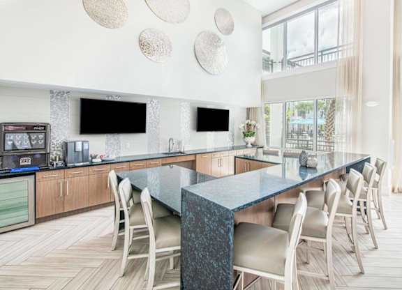 A modern kitchen with a long island and chairs.