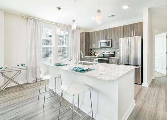 A kitchen with a white island and a breakfast bar.