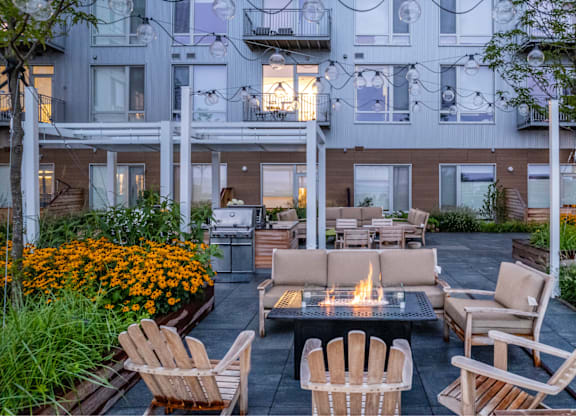 A patio with chairs and a fire pit.