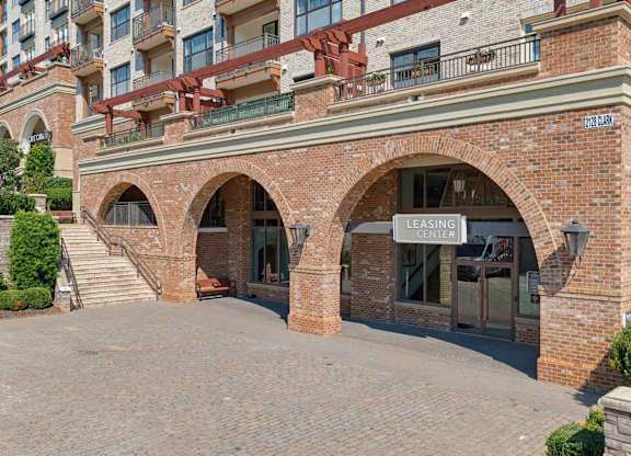 Leasing center entrance at The Clark at Village District, set under brick archways with a paver drive out front.